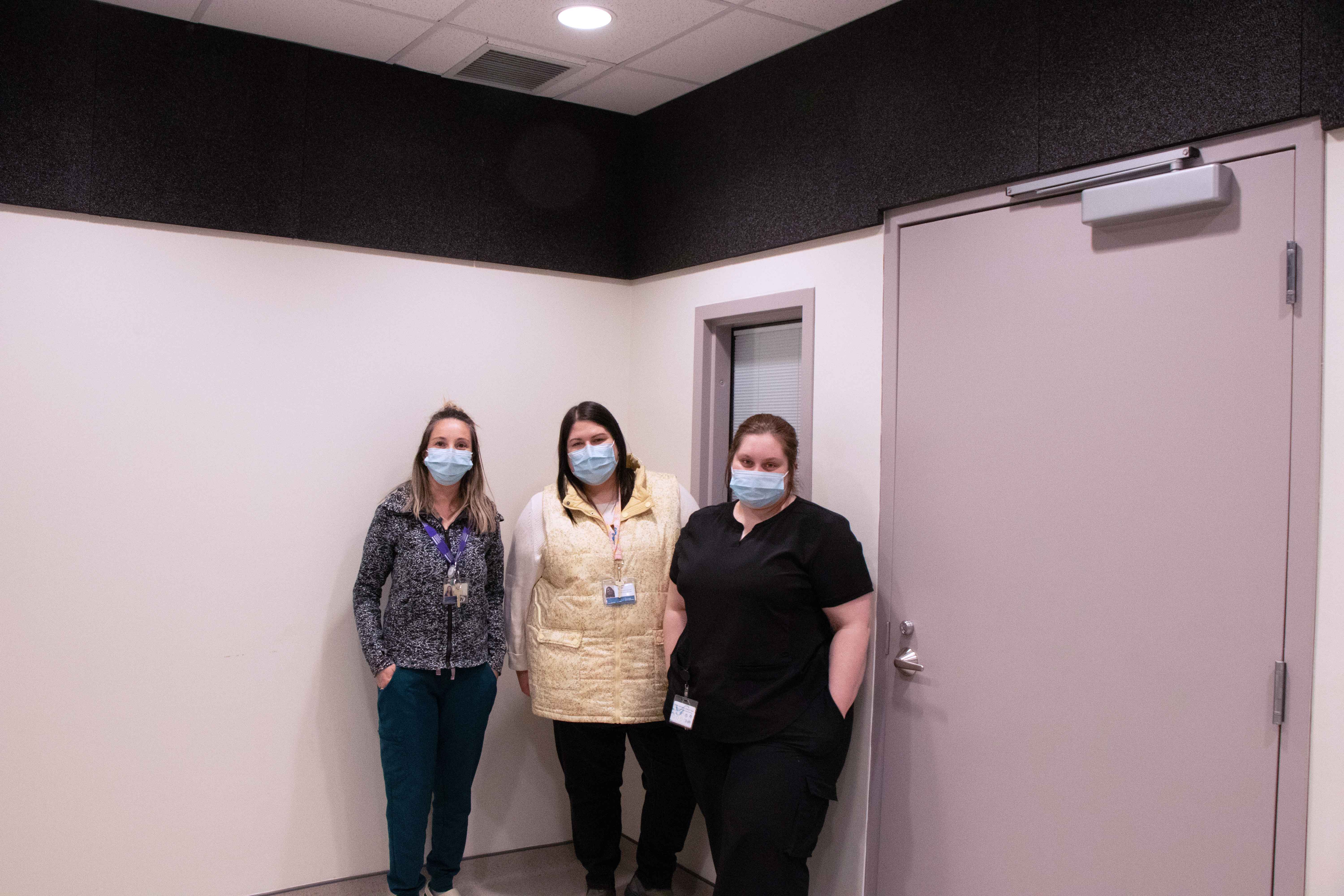 Three care providers stand in a pristine treatment suite