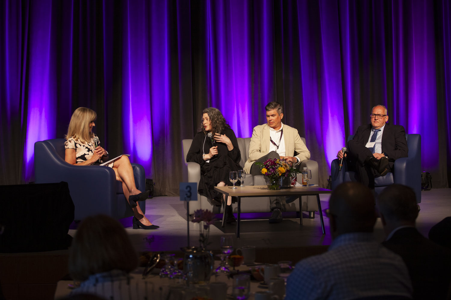 Four people sitting on a stage during a discussion.