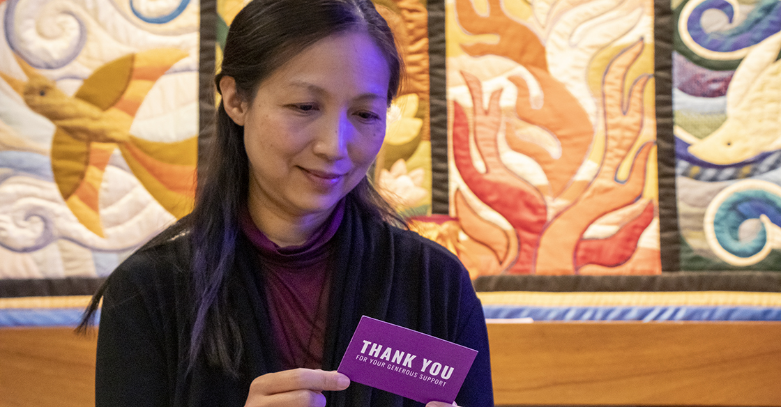 Helen Chan holds a purple thank you card