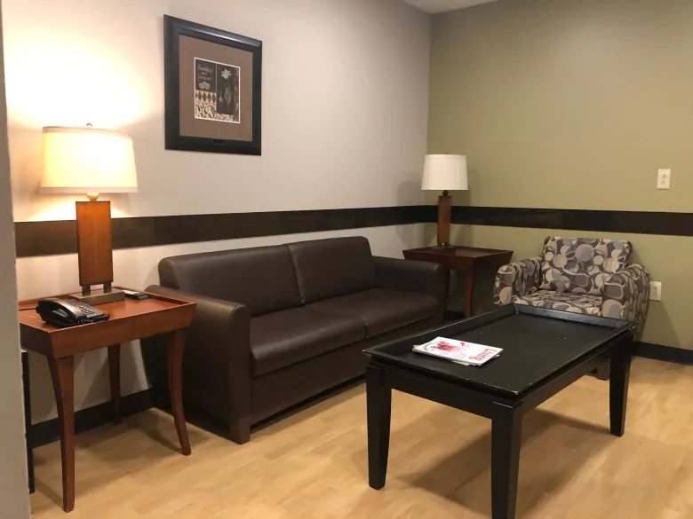 The family room has chips in the walls, old, worn-out furniture and a tiny television.