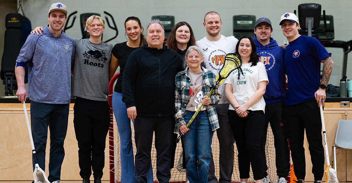 Lacrosse players and staff in gym