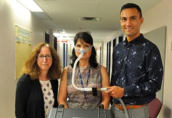 Dr. Debra Morrison and Dr. Hamed Hanafi with the small black sensor attached to the sleep clinic’s sleep apnea breathing machine,  modelled by QEII staff Kelmarie Cole