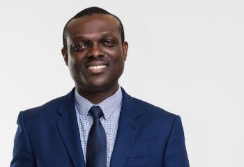 Dr. Vincent Agyapong portrait headshot in a dark blue navy suit against a white background