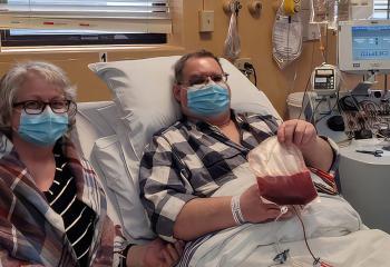 mmaline Jesso (left) pictured with her husband, Charles, during his lifesaving CAR-T therapy treatment.