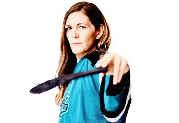 Young woman in blue jersey, posing with hockey stick