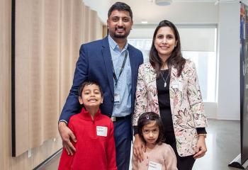 Parents and their two young children pose at announcement event