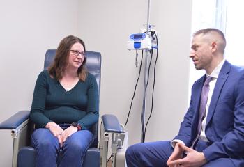  A female patient and male physician sitting down , mid-conversation. 