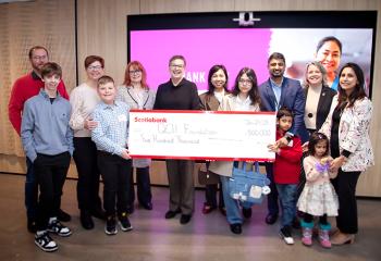 A group of people celebrate Scotiabank's donation to the NICHE program with a large cheque.