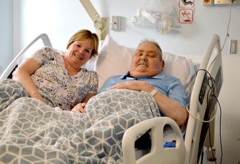 A patient and his wife share a moment in a cuddle bed in the QEII's palliative care unit.