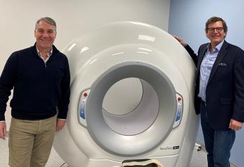 Two QEII physicians stand in front of the new cone beam CT scanner.