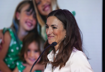 Dr. Jennifer Johnston stands at the podium, making her Better Ring pitch at Innovation Den 2023.