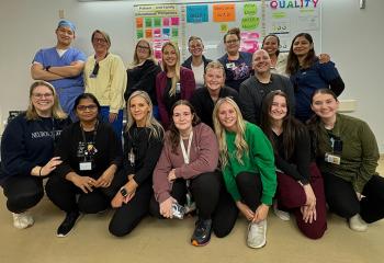 A group of QEII neurosurgery and spine surgery healthcare workers pose for the camera.