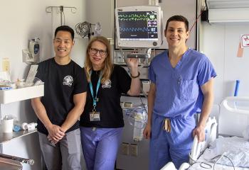 QEII Burn Unit staff stand in a patient room, displaying the new IMCU monitor.