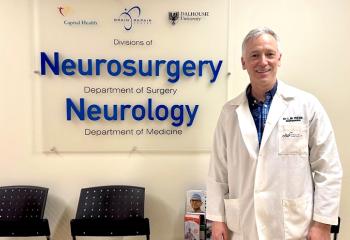 Dr. Lutz Weise stands in front of the neurosurgery sign at the QEII.