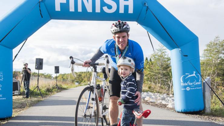 A Ride for Cancer participant hugs his son at the finish line