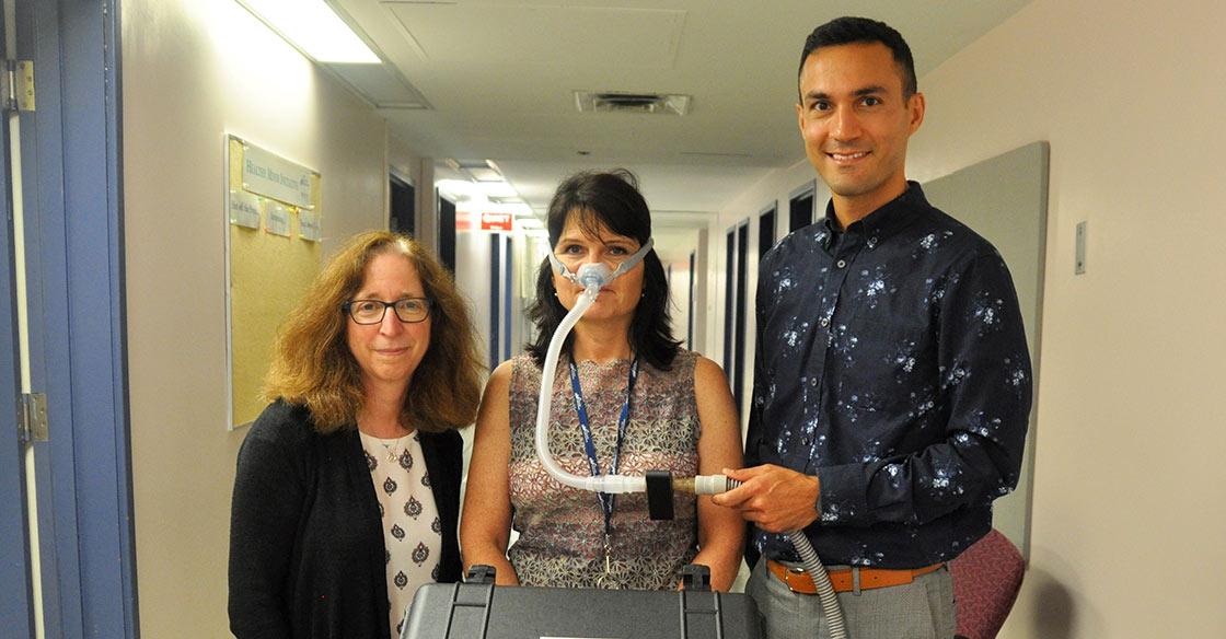 Dr. Debra Morrison and Dr. Hamed Hanafi with the small black sensor attached to the sleep clinic’s sleep apnea breathing machine,  modelled by QEII staff Kelmarie Cole