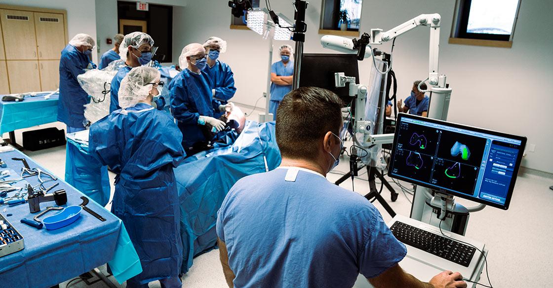 a healthcare team surrounds the orthopaedic surgical robot