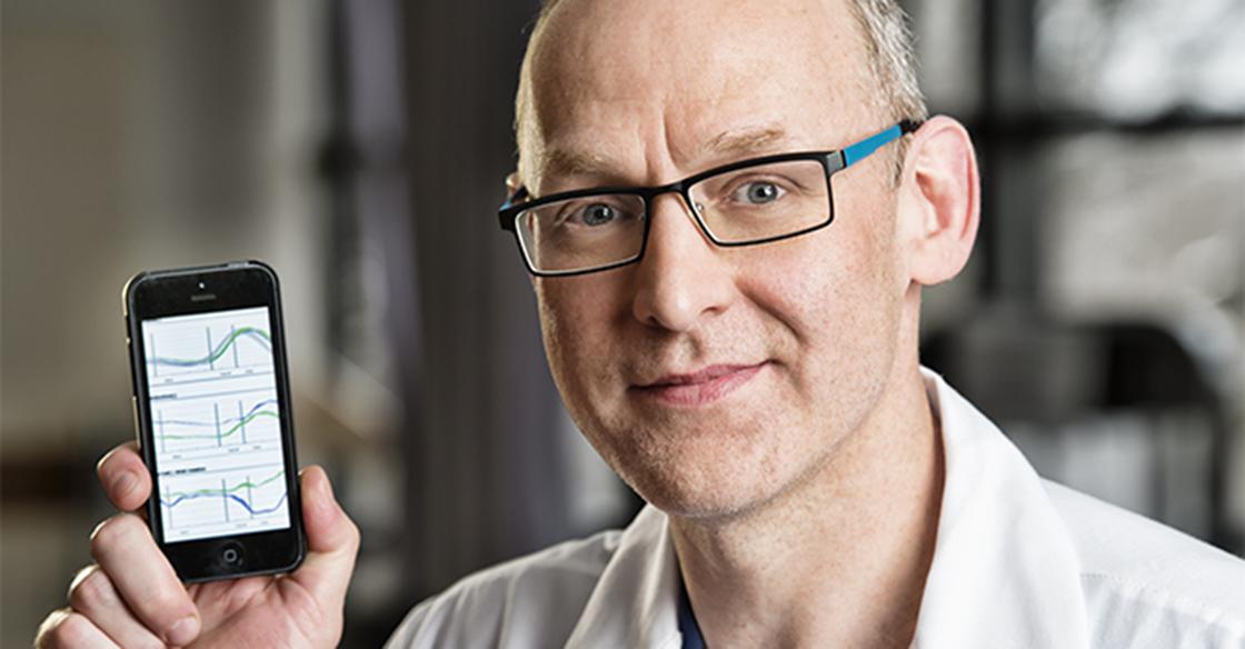 Close up of doctor with glasses holding a cell phone 