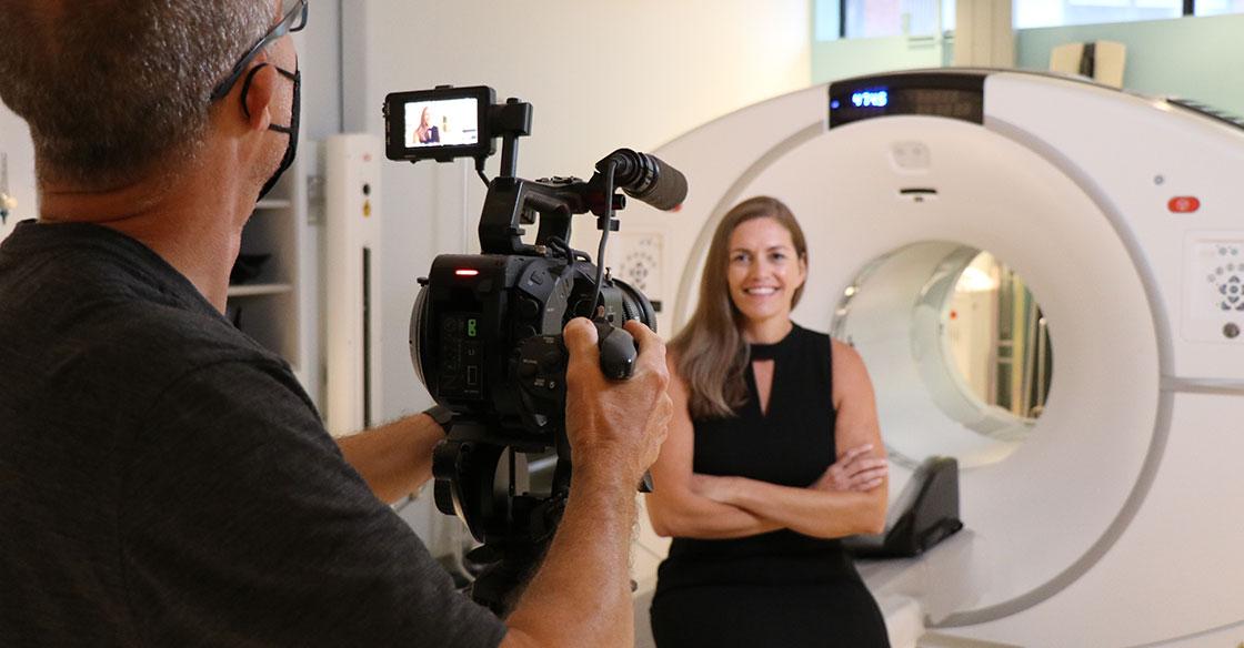 A video camera captures footage of Sharon Needham, who sits in from of a PET-CT scanner at the QEII