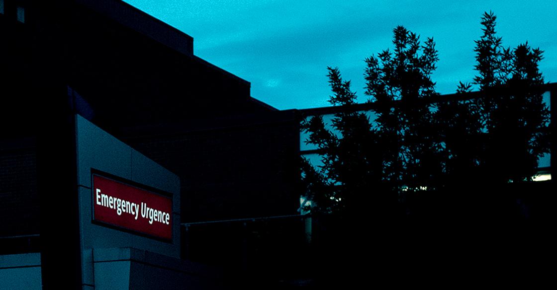 A close up outdoor night time photo of the emergency sign on the Halifax Infirmary building