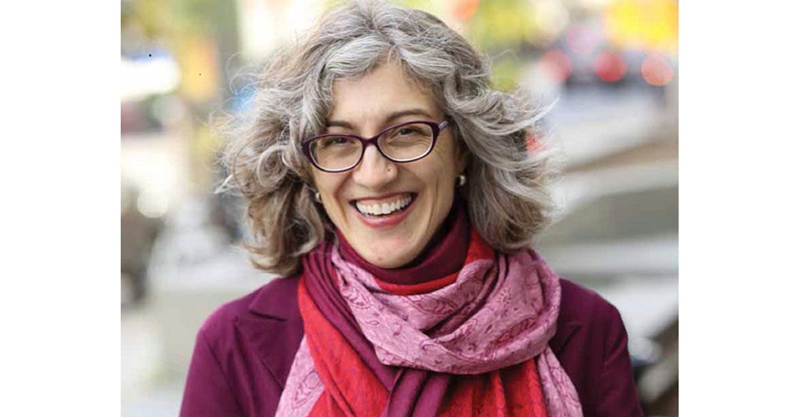 Headshot of Dr. Mary Ellen Macdonald, wearing a burgundy sweater and pink scarf