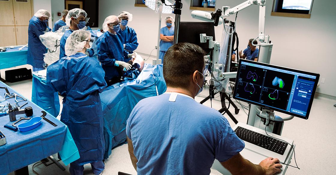 A group of QEII surgeons gather around the Mako SmartRobotic system