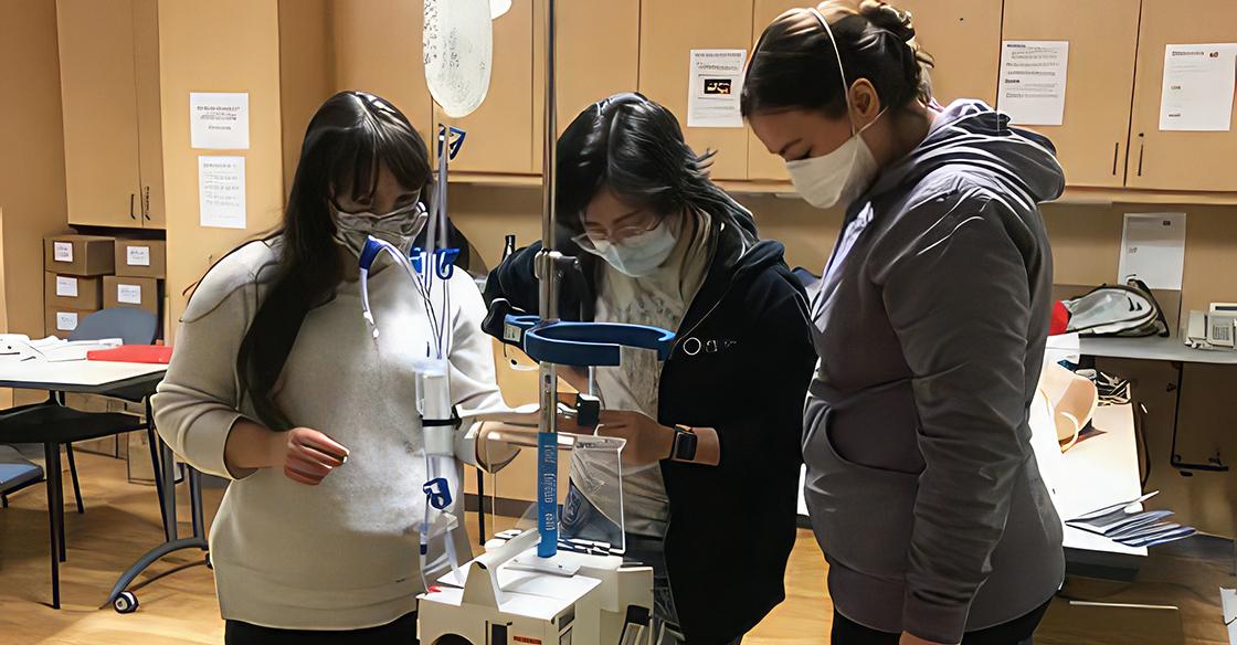 Nurses stand with the Belmont Rapid Infuser 