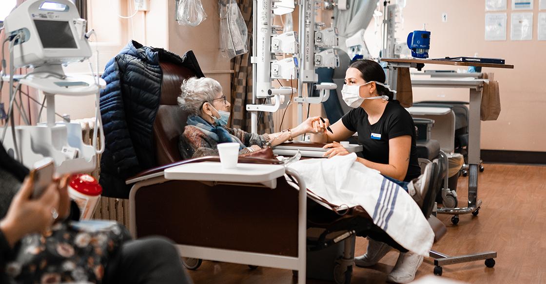 A patient and nurse sit together in the QEII