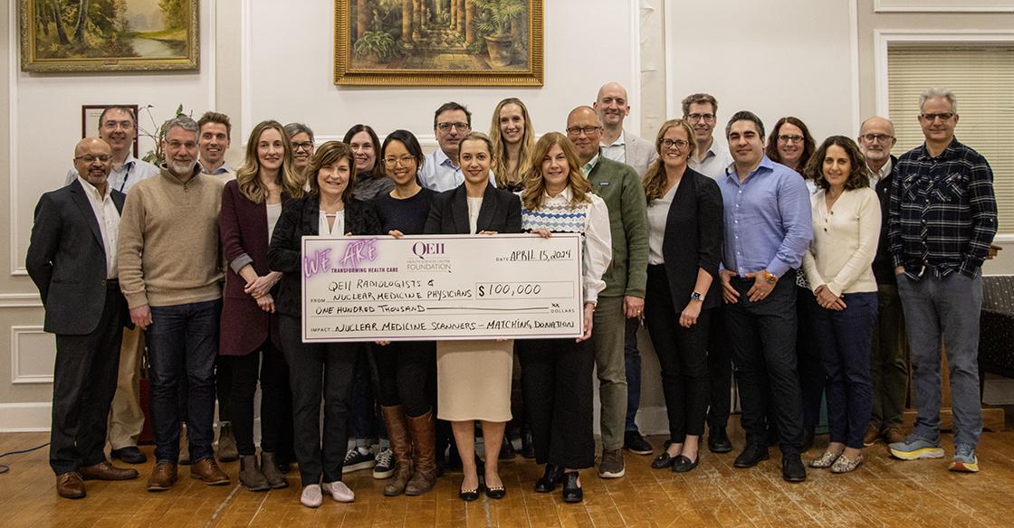 QEII physicians stand with photo of cheque 