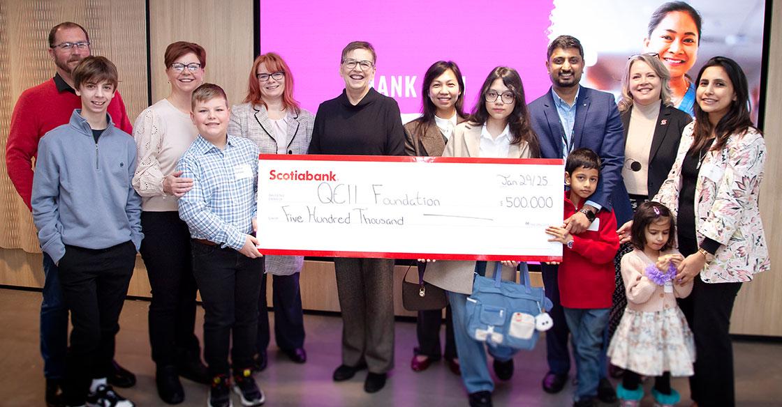 Families and staff holding cheque highlighting $500K donation