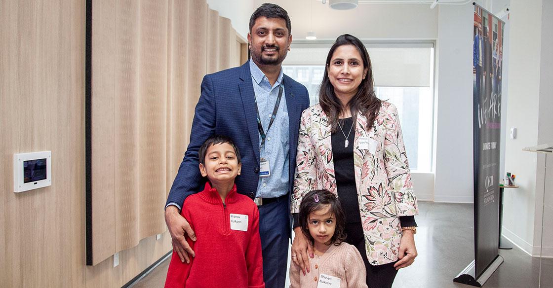 Parents and their two young children pose at announcement event