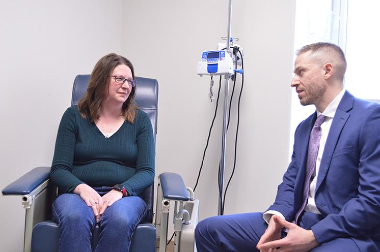  A female patient and male physician sitting down , mid-conversation. 