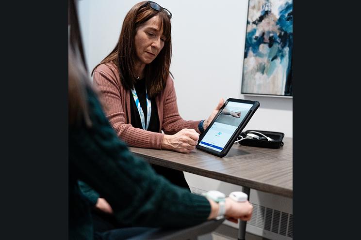 An occupational therapist assesses a patient's progress using new technology.