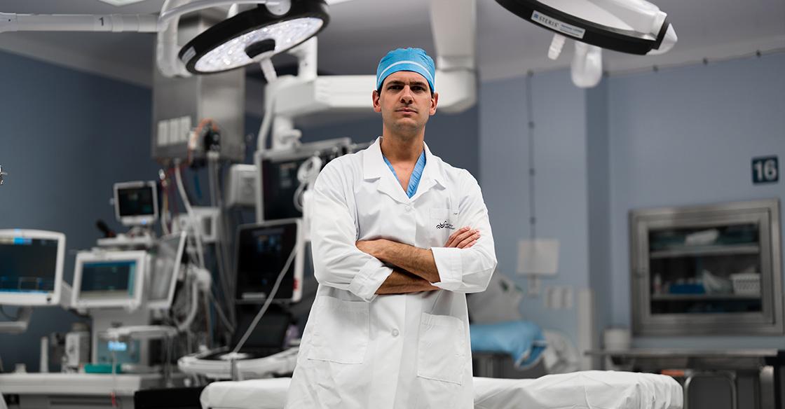Dr Ribeiro standing in OR, with arms crossed and smiling