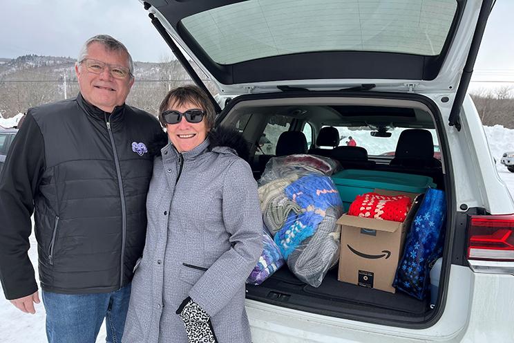 A patient's parents stand by the car full of blanket donations for the QEII.