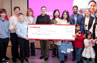 Families and staff holding cheque highlighting $500K donation