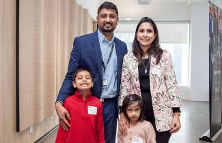 Parents and their two young children pose at announcement event