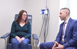  A female patient and male physician sitting down , mid-conversation. 