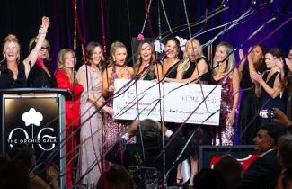 Cheque presentation photo on stage at Orchid Gala event