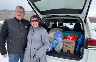 A patient's parents stand by the car full of blanket donations for the QEII.