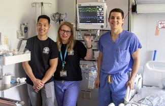 QEII Burn Unit staff stand in a patient room, displaying the new IMCU monitor.