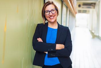 Dr. Robin Urquhart stands smiling in a hallway