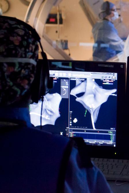 Surgeon looks at a screen while performing surgery at the QEII